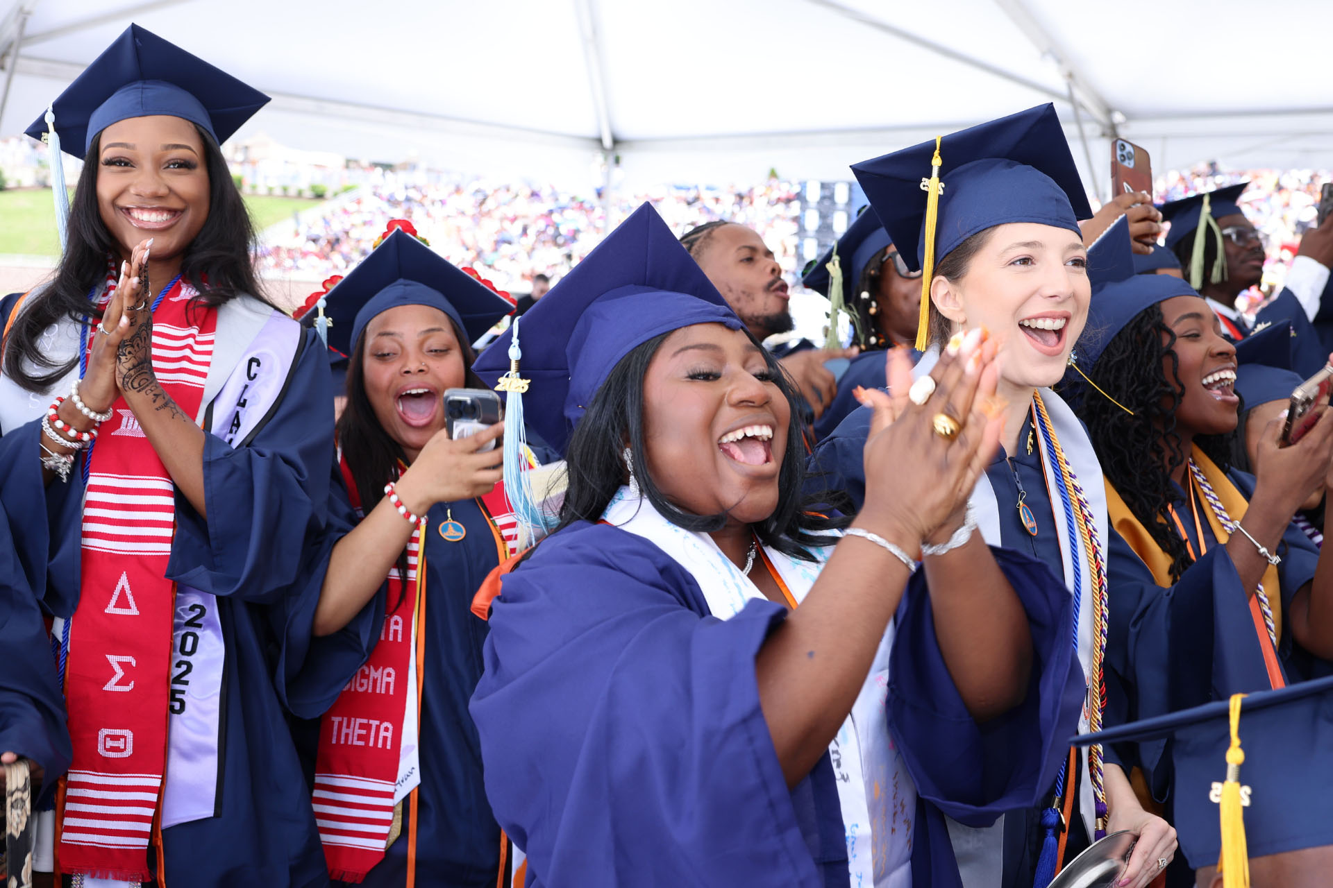 graduating female students cheering at their commencement ceremony