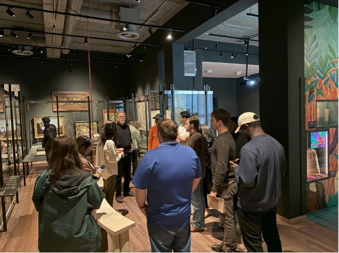 group of students and faculty standing in a museum gallery