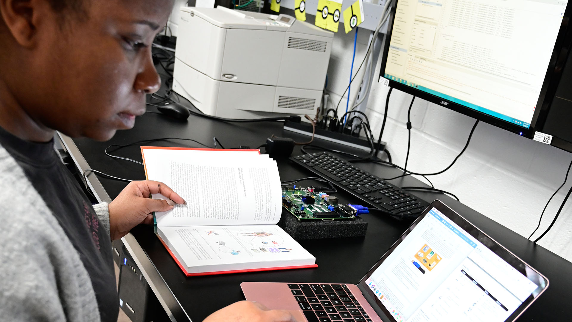 floral bush with students standing behind on sidewalk