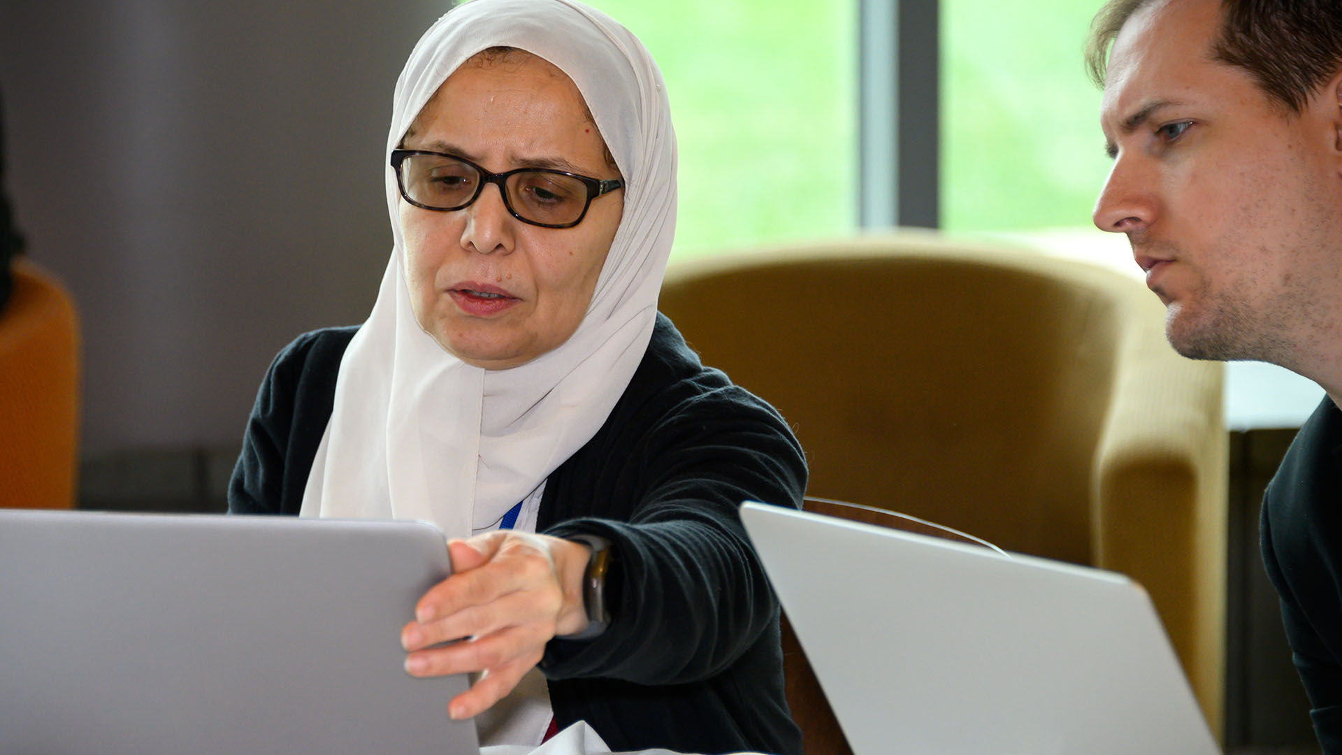 two adults at their laptops
